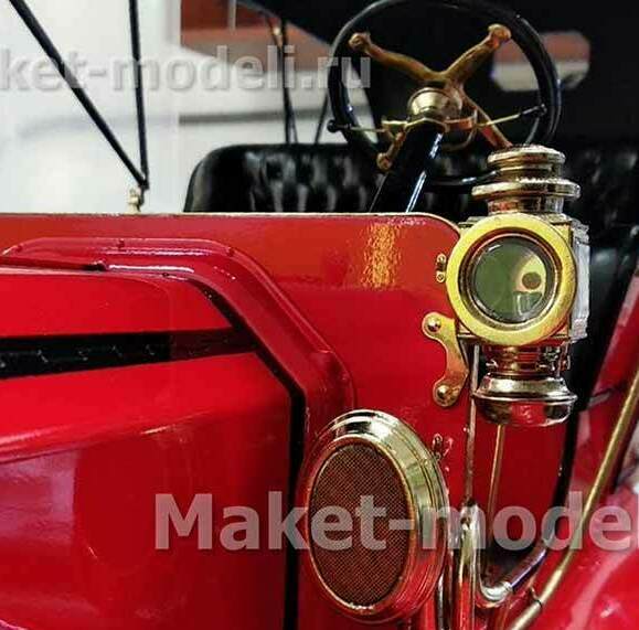 Детально проработанная модель старинного автомобиля в насыщенном красном цвете с выразительными латунными акцентами: фары, декоративные накладки, элементы приборной панели. Видна часть рулевого колеса с классическим дизайном и фрагмент кожаного салона. Модель отличается высокой степенью детализации — идеально подходит для музейной экспозиции или деловой презентации. Изготовлена на заказ с сохранением всех исторических особенностей.