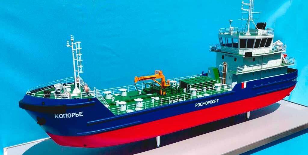 3‑D масштабная модель морского судна с детализированной надстройкой, палубным оборудованием и оранжевой спасательной шлюпкой: демонстрационная миниатюра для выставок, проектных презентаций и музейных экспозиций 3‑D масштабная модель фрагмента палубы морского судна: зелёная палуба, белые леерные ограждения и трапы, оранжевая спасательная шлюпка на штатных креплениях, палубные механизмы (лебёдка, вьюшка), надстройка с дверными проёмами и вентиляционными решётками, навигационное оборудование на верхней площадке; высокая детализация оснастки и конструктивных элементов
