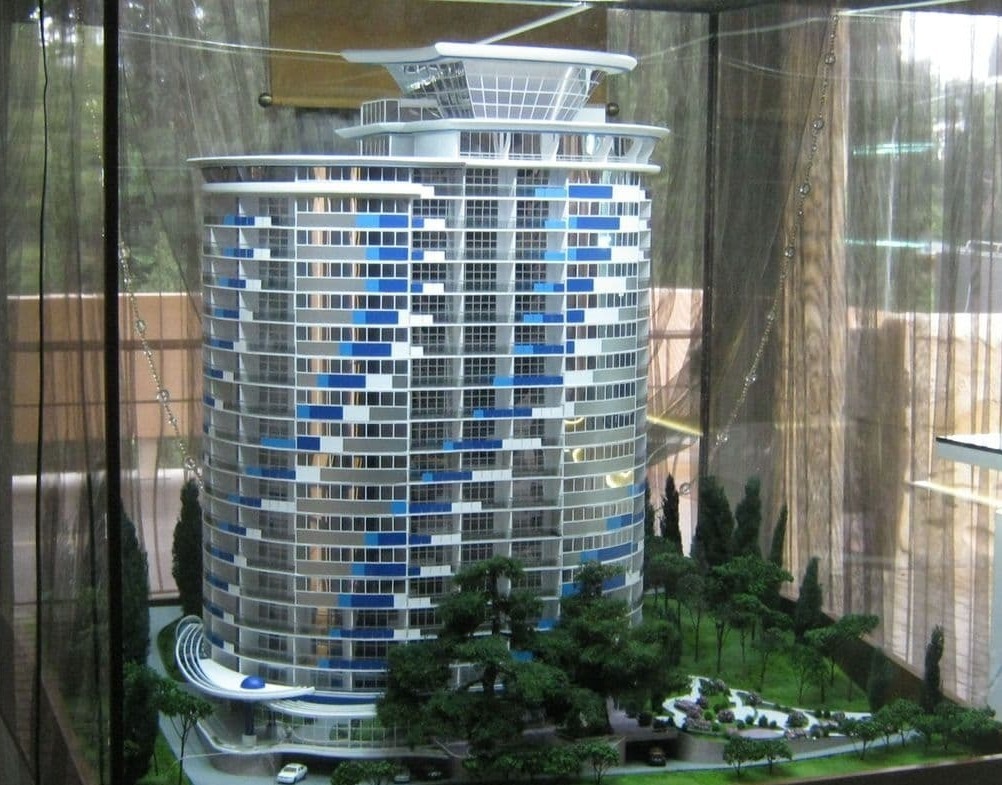 макета 9-ти этажного дома под стеклом с прилегающей территорией