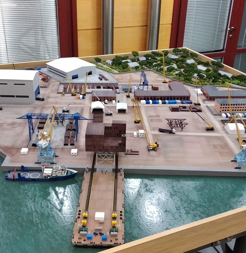 Детализированный макет морского порта, изготовленный на заказ в Макетной мастерской: складские помещения, краны для погрузки и разгрузки, инфраструктурные объекты и пришвартованное судно — наглядная модель портовой инфраструктуры Макет морского порта с реалистичной детализацией: изображены складские здания, несколько кранов для погрузки и разгрузки грузов, инфраструктурные сооружения, участок воды с пришвартованным судном. Демонстрационная модель для презентации логистического комплекса, отображающая организацию работы порта, взаимодействие транспортных средств и объектов инфраструктуры.