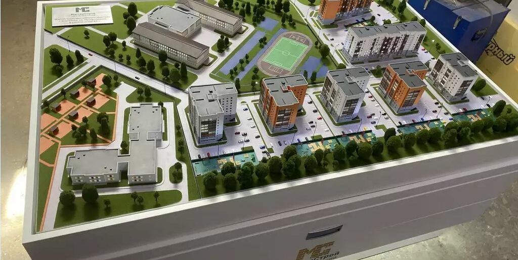 3D-масштабный макет современного жилого комплекса, демонстрирующий планировку квартальной застройки. Включены многоэтажные жилые дома с реалистичными фасадами, школа с прилегающими спортивными площадками, благоустроенные дворы с детскими игровыми зонами. Визуализированы пешеходные дорожки, парковочные места, зелёные насаждения, аллеи и элементы ландшафтного дизайна. На макете отображены ключевые инфраструктурные объекты: спортивная площадка с беговой дорожкой, зоны отдыха, подъездные пути и тротуары. Модель позволяет оценить плотность застройки, распределение жилых и общественных зон, удобство транспортной доступности и уровень озеленения территории. Идеальна для презентации проекта девелоперам, инвесторам и потенциальным покупателям недвижимости.