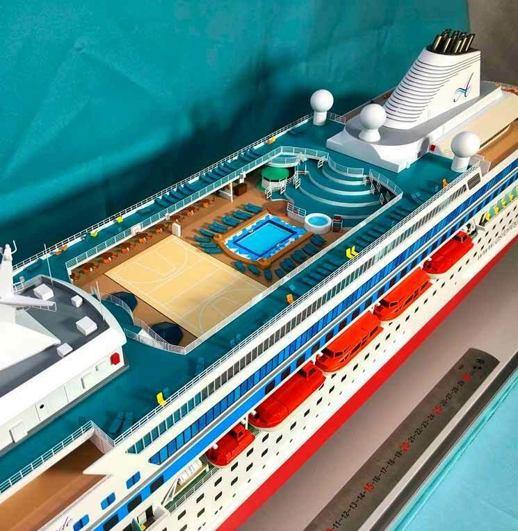 Детальная масштабная модель круизного лайнера: видна верхняя палуба с бассейном, зоной отдыха с шезлонгами, спортивной площадкой и спасательными шлюпками. Проработаны элементы экстерьера — радиолокационные купола, дымовая труба, иллюминаторы. Модель изготовлена на заказ, идеально подходит для пополнения коллекции или использования в музейной презентации. Реалистичные пропорции и цветовые решения создают эффект настоящего судна.