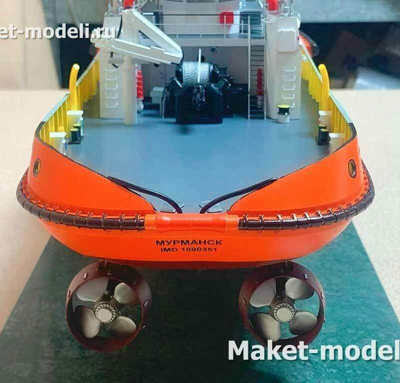 Вид с кормы: хорошо заметны две азимутальные винторулевые колонки в насадках (Kort nozzle), обеспечивающие 360° разворот струи и высокую маневренность. На открытой рабочей палубе — буксирная лебёдка, кран-манипулятор, ограждение палубы и мощный фендерный пояс по периметру корпуса.    На борту нанесено имя «Мурманск».