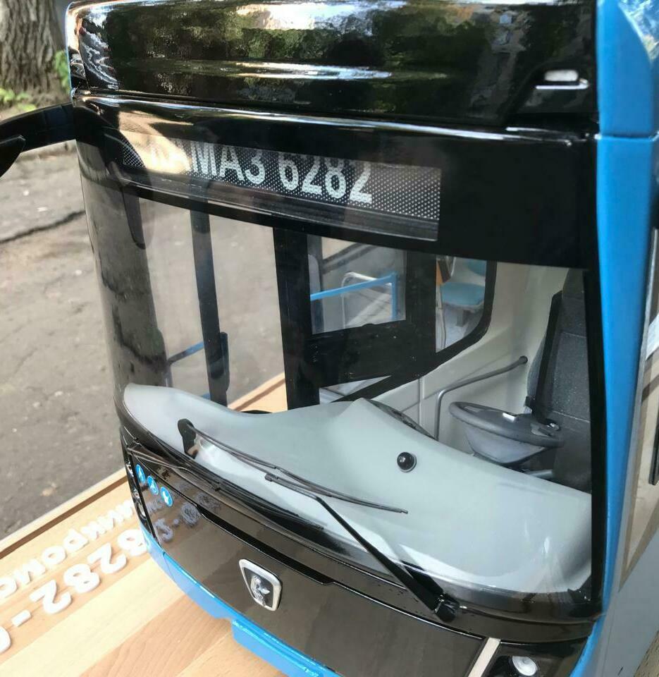На фотографии изображен модель автобуса. Это уменьшенная копия настоящего транспортного средства, выполненная с высокой степенью детализации. На макете видны элементы, характерные для автобуса: ручки для пассажиров, зеркала заднего вида, номерной знак и логотипы.  Макеты автобусов используются для различных целей, включая образовательные программы, выставки, рекламные мероприятия и коллекционирование. Они могут служить для обучения детей правилам дорожного движения или для демонстрации новых моделей автобусов потенциальным клиентам.