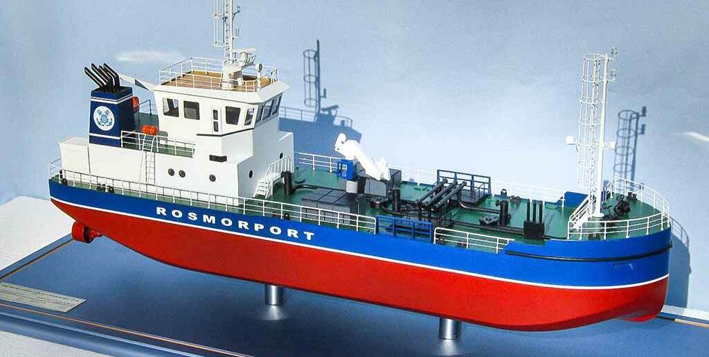 Масштабная модель обстановочного судна «Rosmorport» — детализированная копия морского судна с фирменной раскраской, антеннами и палубным оборудованием, модель для коллекционеров и музейных экспозиций, изготовленная на заказ в макетной мастерской Maket-modeli.ru Реалистичная масштабная модель обстановочного судна компании «Rosmorport»: красный корпус с синей ватерлинией и белой надписью «ROSMORPORT», детально проработанная надстройка с антеннами и радиолокационным оборудованием, палубные механизмы, спасательные круги, леерные ограждения. Модель установлена на подставке, идеально подходит для коллекционеров моделей судов, оформления морских музеев, тематических выставок, посвящённых флоту и деятельности «Росморпорта». Демонстрирует конструктивные особенности современных обстановочных судов.