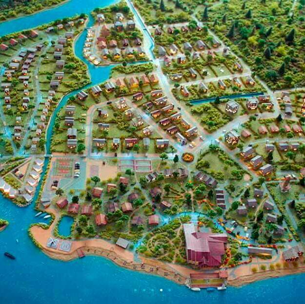 Детализированный макет загородного коттеджного посёлка у воды: дома, пляж, причалы для яхт, зоны отдыха и зелёные насаждения сверху