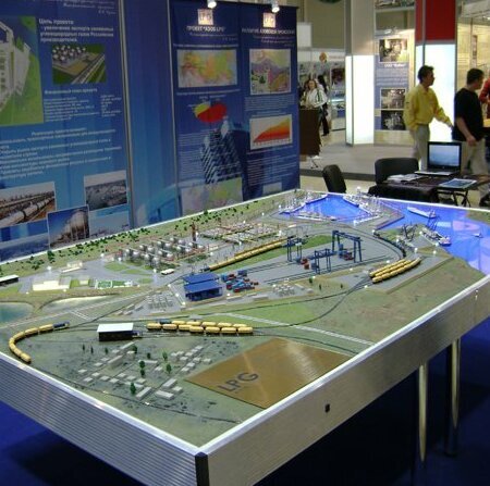 Детальный макет промышленного комплекса, демонстрирующий планировку крупного производственного предприятия. В центре композиции — основные производственные корпуса с чётко выделенными зонами цехов и административных помещений. Вокруг расположены складские терминалы, погрузочно-разгрузочные площадки, железнодорожные пути и автотрассы, связывающие объект с внешней транспортной сетью. Присутствуют элементы благоустройства: аллеи, газоны, миниатюрные деревья. Проработаны инженерные коммуникации — линии электропередач, трубопроводы, системы водоотведения. Модель включает макеты спецтехники и грузовых автомобилей, что подчёркивает логистическую составляющую проекта. Подсветка отдельных зон акцентирует внимание на ключевых узлах производства. Подходит для демонстрации инвестиционных проектов, планирования застройки промышленных территорий, использования в экспозициях отраслевых выставок.