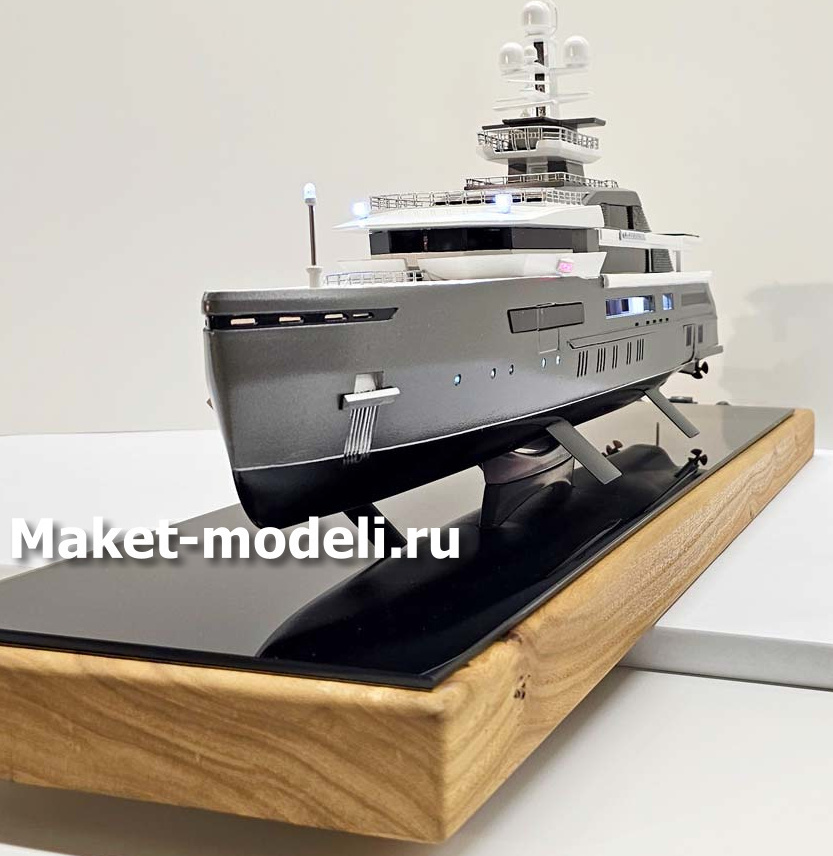 Масштабный 3D макет современной моторной яхты. Модель выполнена с высокой детализацией: видны палубы, вертолетная площадка, радиолокационная мачта, иллюминаторы и элементы корпуса. Макет установлен на деревянной подставке с глянцевой вставкой.