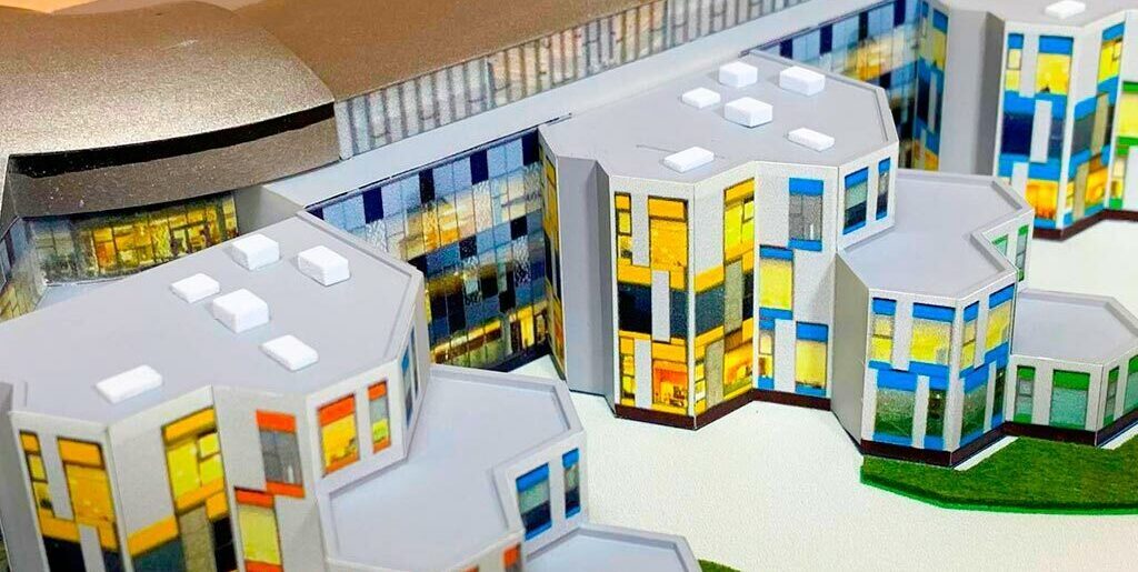 3-D масштабный архитектурный макет гимназии с модульными зданиями, купольным актовым залом, зонированной территорией и детской площадкой, изготовленный на заказ в макетной мастерской для демонстрации