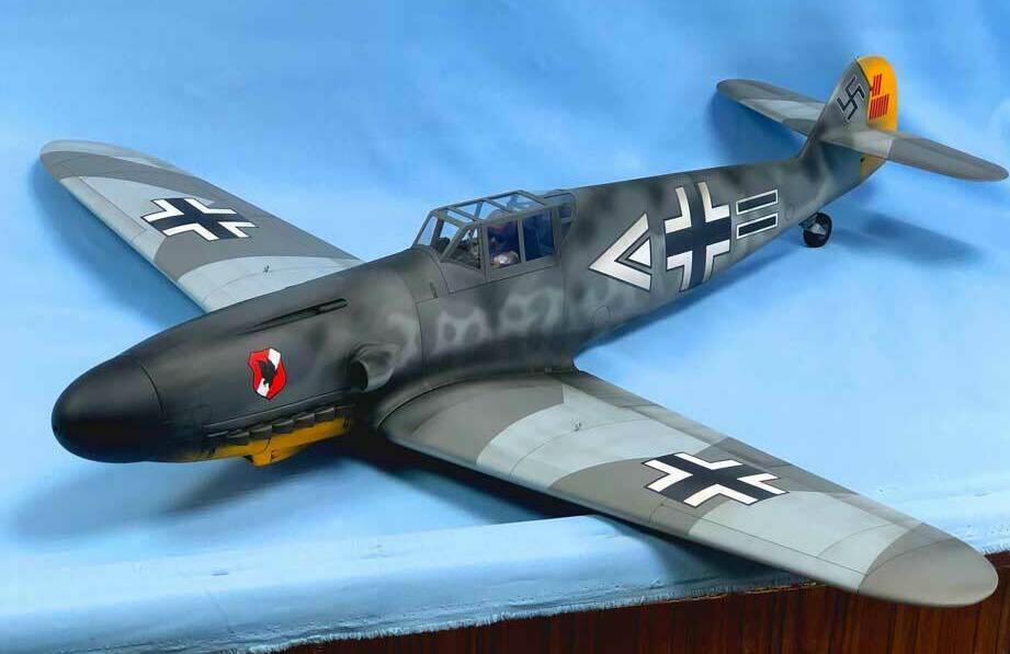 Детализированная масштабная модель немецкого истребителя Messerschmitt BF-109G-6 с характерной камуфляжной окраской и опознавательными знаками Люфтваффе: чёрными крестами на крыльях и фюзеляже, жёлтым хвостовым оперением и красно-белым знаком на носу. Реалистичная кабина пилота, проработанные элементы корпуса и шасси. Идеальный выбор для коллекционеров, музейных экспозиций и тематических диорам, посвящённых Второй мировой войне.