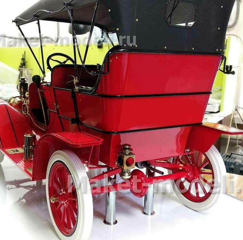 Детально проработанная модель классического автомобиля Ford Model T 1908 года в ярком красном цвете с чёрным тентом. Выделяются латунные элементы отделки, белые покрышки колёс, аутентичные фары и декоративные накладки. Модель установлена на металлических подставках, демонстрирует оригинальный дизайн начала XX века — идеальный экспонат для музея или деловой презентации. Изготовлена на заказ с сохранением всех исторических деталей.