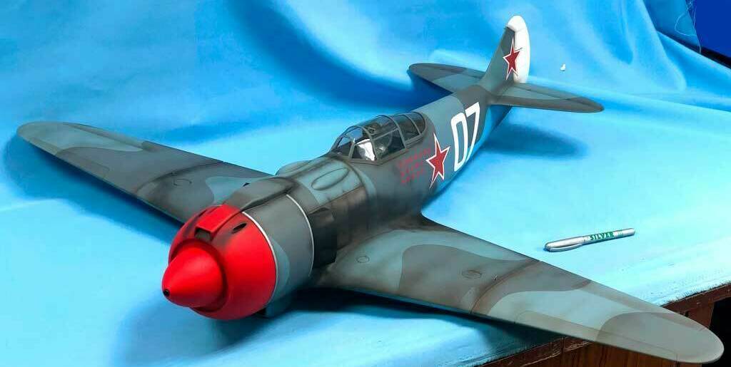 Детализированная масштабная модель советского истребителя Ла-5 с характерными красными звёздами на фюзеляже и хвосте, камуфляжной окраской и номером «07». Реалистичная копия легендарного самолёта времён Великой Отечественной войны, идеально подходящая для коллекционеров и любителей авиамоделей.