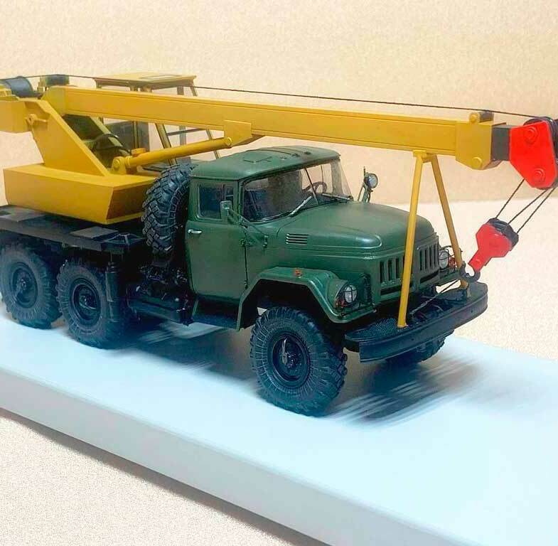 Масштабная коллекционная 3Д модель автокрана ЗИЛ-131: детализированный макет спецтехники для презентаций и коллекций Уменьшенная копия грузового автомобиля ЗИЛ-131 с желтой крановой установкой, выдвижной стрелой и красным крюком на белом демонстрационном подиуме , изготовленная на заказ в макетной мастерской Maket-modeli.ru