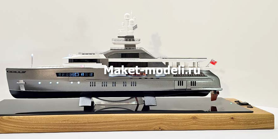 Масштабный 3D макет современной моторной яхты. Модель выполнена с высокой детализацией: видны палубы, вертолетная площадка, радиолокационная мачта, иллюминаторы и элементы корпуса. Макет установлен на деревянной подставке с глянцевой вставкой.