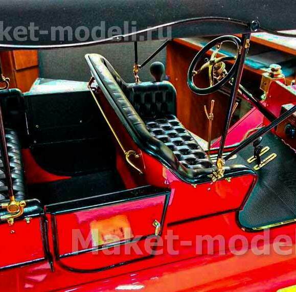 Презентационная модель ретро-автомобиля с ярко-красным кузовом, кожаными сиденьями с тафтингом, латунными деталями и классическим рулевым колесом. Идеальна для музейной экспозиции или деловой презентации — детализированная копия с аутентичными элементами интерьера.