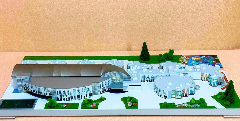 3-D масштабный архитектурный макет гимназии с модульными зданиями, купольным актовым залом, зонированной территорией и детской площадкой, изготовленный на заказ в макетной мастерской для демонстрации