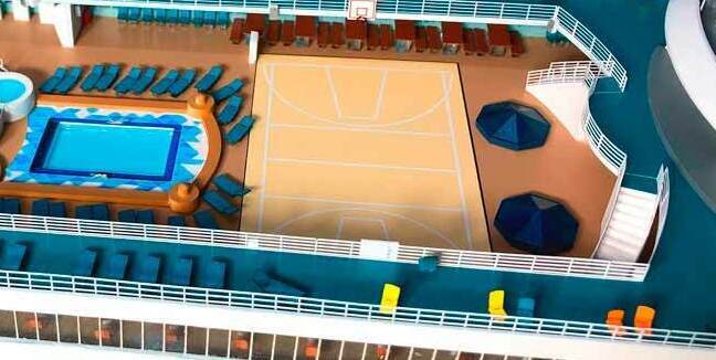 Детальный макет верхней палубы пассажирского судна в масштабе: центральный бассейн с голубой водой, окружённый шезлонгами; просторная баскетбольная площадка с разметкой; многоуровневая зона отдыха с амфитеатром и лежаками; спасательные шлюпки, радиолокационные купола и перила палубы. Проработаны мелкие элементы — зонты, лестницы, архитектурные детали. Модель изготовлена на заказ в студии макетов, идеально подходит для экспозиции в музее или пополнения коллекции морских судов. Реалистичные пропорции и цветовая гамма передают атмосферу настоящего круизного лайнера.