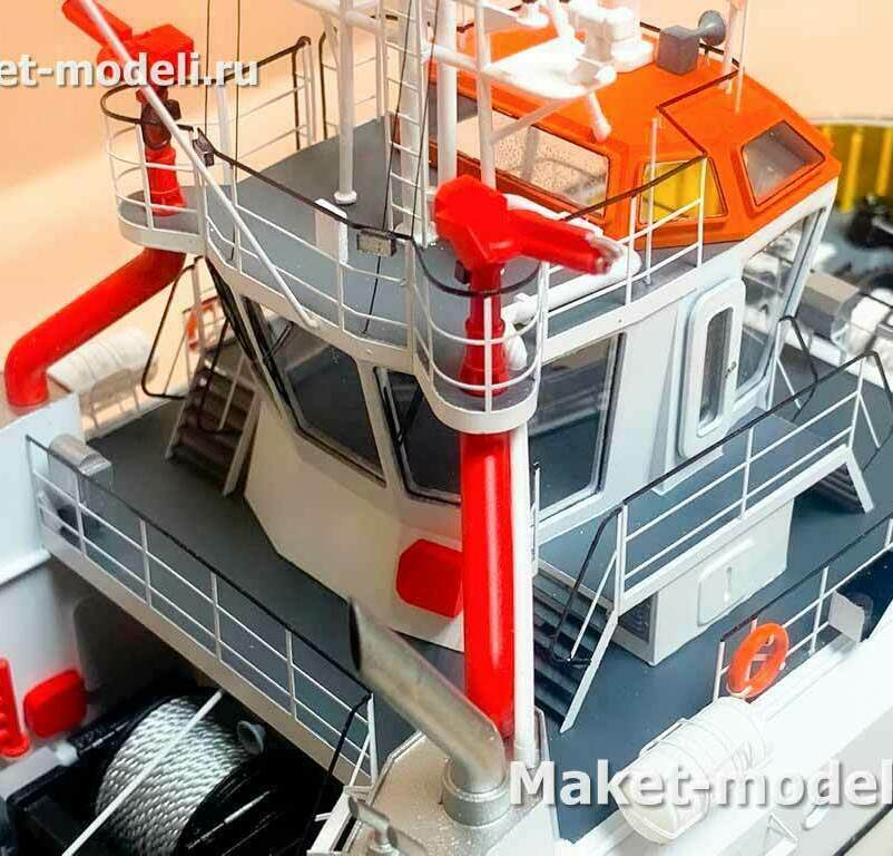 Назначение: маневровка и эскорт судов в порту, буксировка, аварийно‑спасательные работы и пожаротушение на акватории. • Судовая надстройка с ходовым мостиком/рубкой; остеклённые крылья мостика с ограждениями и трапами. • Два лафетных ствола пожарной системы (водяные/пенные мониторы) на тумбах, подключенные к магистралям. • Мачта с навигационными огнями и антенным оборудованием на крыше рубки (оранжевый козырёк — спасательная окраска). • На главной палубе — буксирная лебёдка с тросовым барабаном; рядом леерные ограждения, швартовная арматура. • Элементы спасательного снабжения: спасательный круг, контейнер с убыточным средством (плот/катушка), вентиляционные и выхлопные патрубки.