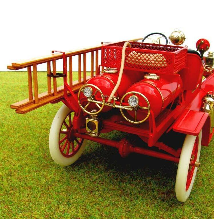 3D-масштабная модель коллекционного пожарного автомобиля Ford Model T 1914 года в масштабе 1:24. Видна передняя часть кабины с чёрным стёганым сиденьем, массивным рулевым колесом с красной рукояткой и латунными деталями управления. Присутствуют аутентичные элементы: фара в хромированном корпусе, колокол, рычаги и клапаны пожарного оборудования. Красные акценты сочетаются с полированными латунными вставками, подчёркивая винтажный стиль модели. Идеальный экземпляр для коллекционеров и любителей истории пожарной техники.