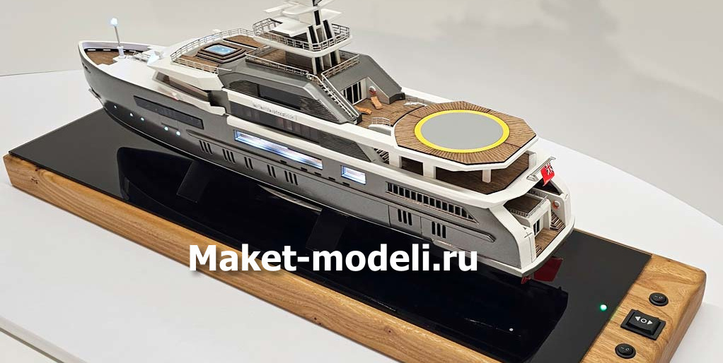 Масштабный 3D макет современной моторной яхты. Модель выполнена с высокой детализацией: видны палубы, вертолетная площадка, радиолокационная мачта, иллюминаторы и элементы корпуса. Макет установлен на деревянной подставке с глянцевой вставкой.