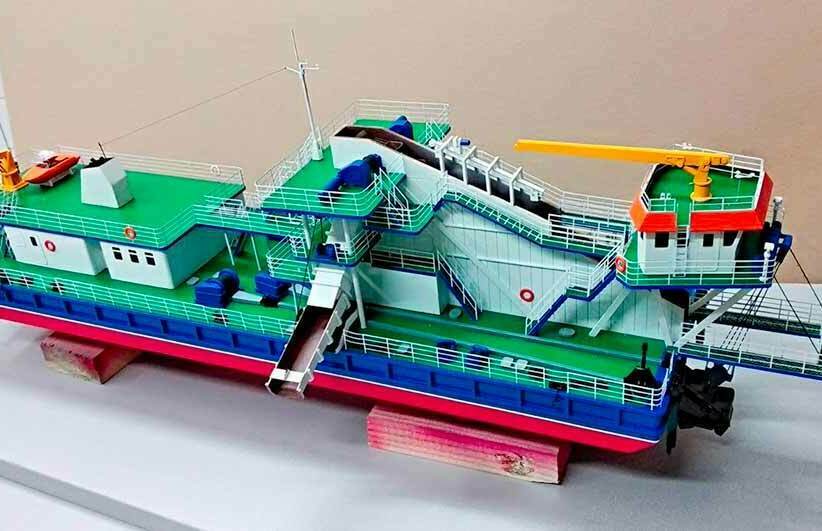 Макет судна. Макет земснаряда – масштабная модель рабочего технического судна Масштабный цветной макет земснаряда: рабочее техническое судно с конвейером, краном и палубами, установленное на подставке