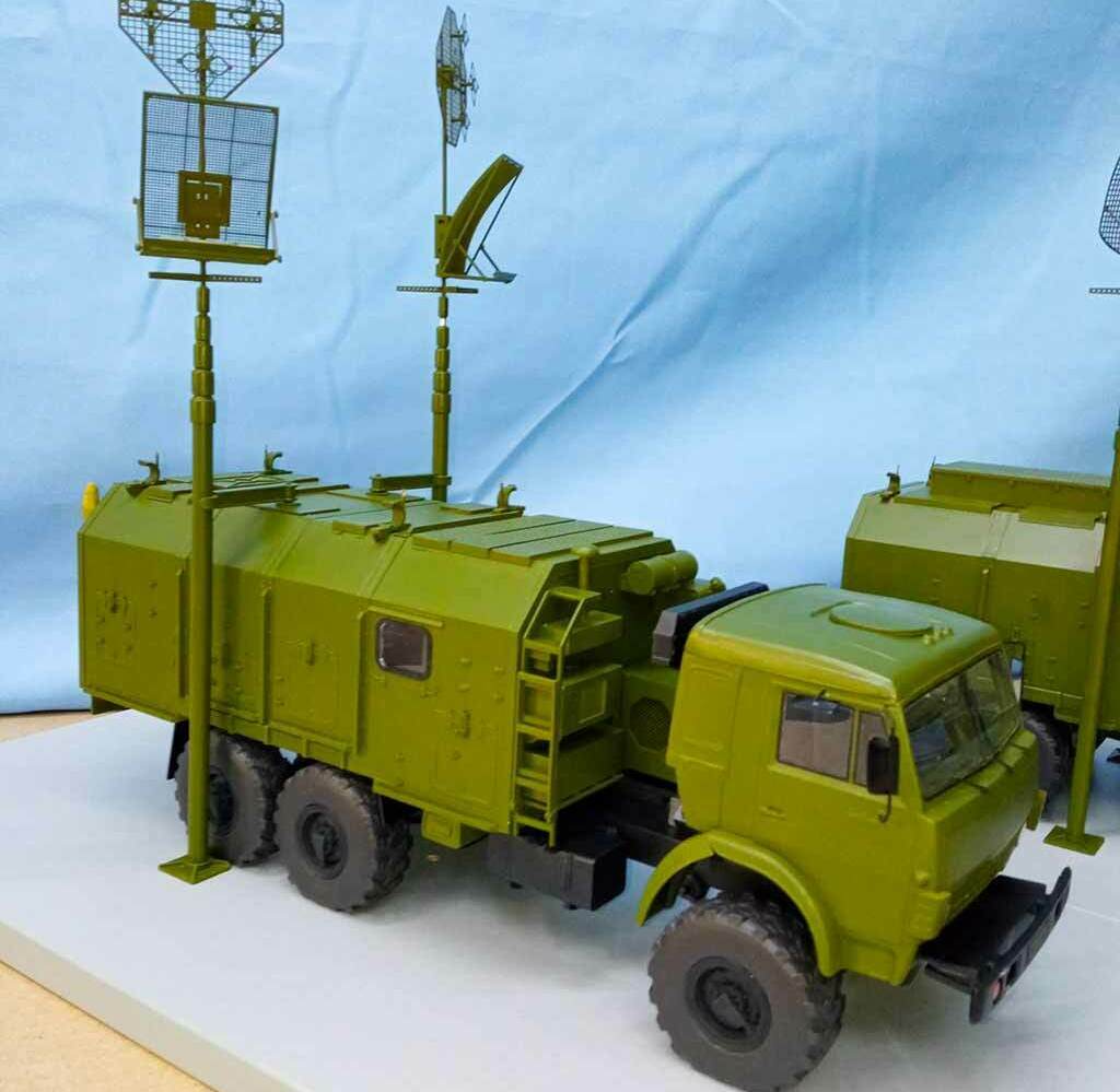 Модель военной техники, представляющий собой модифицированный грузовой автомобиль с установленным на нем радиолокационным оборудованием. Это транспортное средство оборудовано антеннами, которые расположены на специальной платформе сверху. Вероятно, это макет мобильной радиолокационной станции, которая используется для обнаружения воздушных целей и контроля воздушного пространства. Такие системы могут применяться в военных и гражданских целях для мониторинга воздушного трафика, предупреждения о воздушном нападении и поддержки противовоздушной обороны.