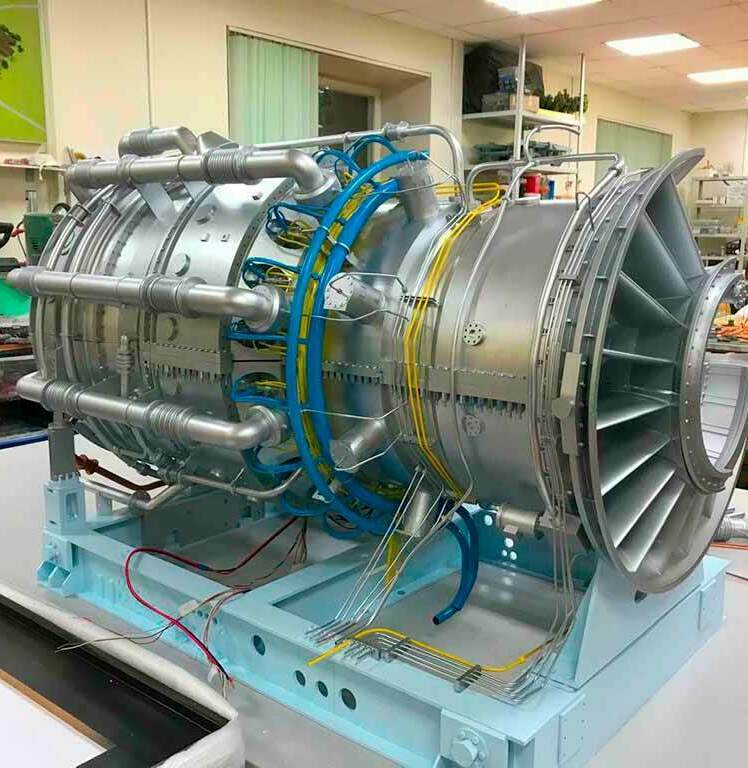 Детализированный макет газовой турбины промышленного назначения: чётко видны лопатки турбинного колеса, системы подачи и отвода газа, разветвлённая сеть трубопроводов (синие и жёлтые линии), крепёжные элементы, монтажные узлы и корпус турбины. Модель установлена на демонстрационной подставке, демонстрирует внутреннюю конструкцию и принцип работы газотурбинной установки. Подходит для использования на отраслевых выставках, в образовательных целях, для презентаций инженерных решений в сфере энергетического оборудования. Реалистичная проработка элементов подчёркивает сложность и точность конструкции.