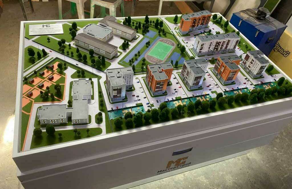 Детализированный архитектурный макет жилого комплекса: многоквартирные дома, административные здания, дороги, парковки, зелёные зоны и футбольная площадка изготовленный на заказ для выставки