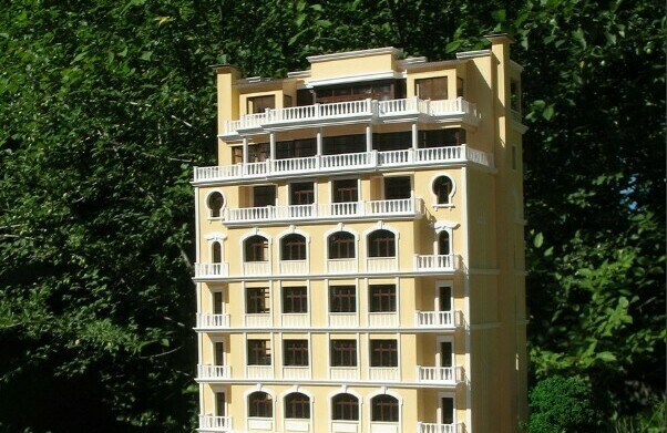 Модель жилого здания со своей территорией и парковкой с машиной