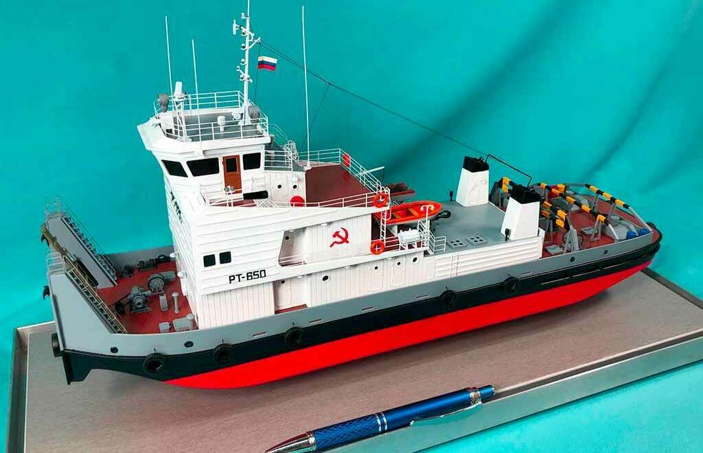 Масштабный макет судна РТ‑650 – детализированная модель рабочего корабля Макет судна / корабля на заказ. Фото масштабного макета судна РТ‑650 с красным корпусом и надстройкой, модель корабля на подставке с ручкой для сравнения размеров