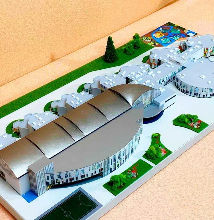 3-D масштабный архитектурный макет гимназии с модульными зданиями, купольным актовым залом, зонированной территорией и детской площадкой, изготовленный на заказ в макетной мастерской для демонстрации