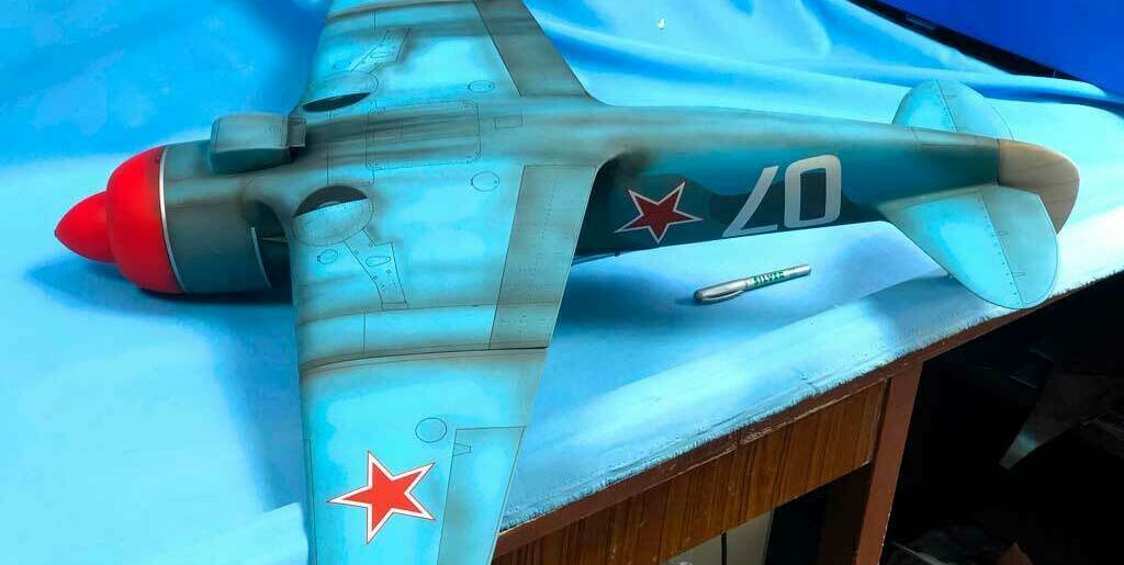 Детализированная масштабная модель советского истребителя Ла-5 с характерными красными звёздами на фюзеляже и хвосте, камуфляжной окраской и номером «07». Реалистичная копия легендарного самолёта времён Великой Отечественной войны, идеально подходящая для коллекционеров и любителей авиамоделей.