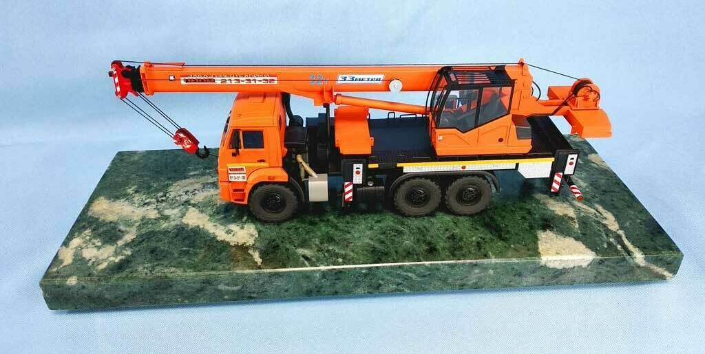 Масштабная модель автокрана «Клинцы» на базе КамАЗ с трёхсекционной телескопической стрелой длиной 33 метра. Яркий оранжевый цвет, детализированная кабина оператора, крюковая подвеска. Подходит для демонстрации строительной спецтехники, иллюстрирует возможности подъёма и перемещения грузов.