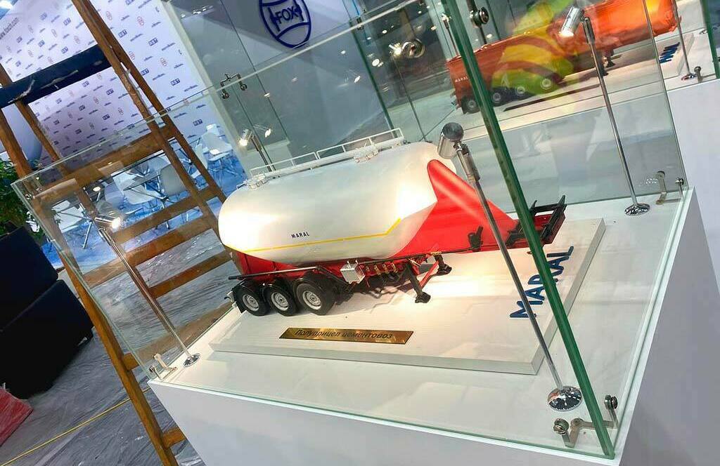 Экспозиция промышленных моделей на выставке: макеты грузовых автомобилей MARAL и спецтехники — инновации в производстве, изготовленные на заказ в макетной мастерской Maket-modeli.ru Выставка с детализированными макетами грузовой техники MARAL и промышленного оборудования на выставочном стенде. Демонстрация достижений в сфере металлообработки и производства транспортных средств: модели автоцистерн и полуприцепов в стеклянных витринах, дополненные интерактивным экраном и рекламным баннером с изображением специалиста за работой.