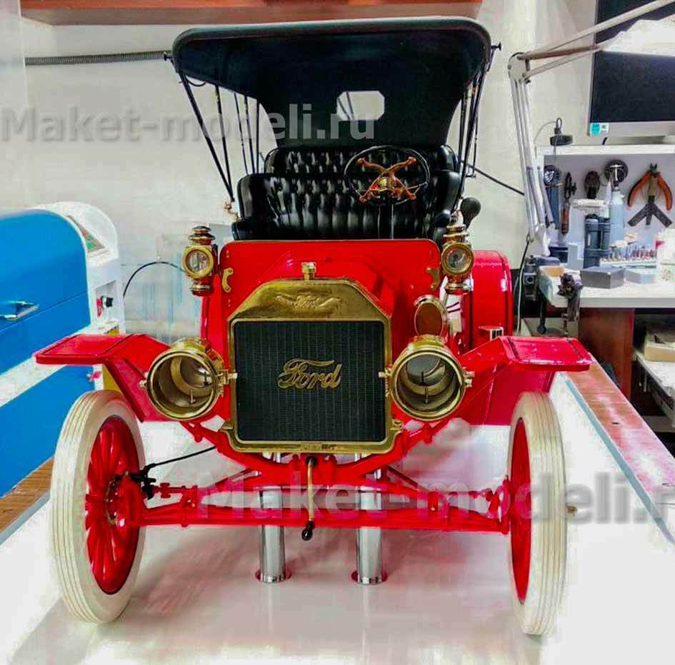 Детализированная модель ретро-автомобиля Ford Model T 1908 года в ярко-красном исполнении с чёрным тентом и латунными элементами. Презентационная копия для музея с аутентичными деталями: классические фары, решётка радиатора с логотипом Ford, колёса с белыми покрышками. Изготовлена на заказ для эффектной демонстрации истории автомобилестроения.