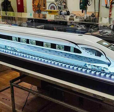 Масштабный выставочный макет скоростного электропоезда с внутренней подсветкой в защитном акриловом коробе — изготовление моделей транспорта, изготовленный на заказ в макетной мастерской Maket-modeli.ru Высокодетализированная масштабная модель современного пассажирского экспресса на рельсах с диодной иллюминацией под прозрачным колпаком, выполненная в макетной мастерской для презентаций.