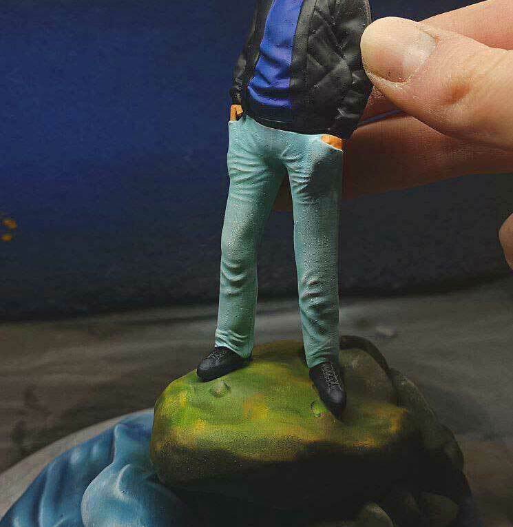 3D-фигурка человека на заказ по фото: стильный образ с солнцезащитными очками и кожаной курткой, напечатанная на 3D-принтере. Реалистичная статуэтка в расслабленной позе на декоративном основании — уникальный подарок! Реалистичная 3D-фигурка человека, изготовленная по фотографии на 3D-принтере. Статуэтка изображает мужчину в расслабленной позе, стоящего на стилизованном основании, напоминающем камень у воды. Одет в чёрную кожаную куртку поверх синего худи, светло-голубые джинсы и чёрные туфли. На лице — солнцезащитные очки, волосы аккуратно уложены. Детализированная проработка одежды, черт лица и позы придаёт фигурке максимальную реалистичность. Подходит для коллекционирования, украшения интерьера или в качестве персонализированного подарка. Пример качественной 3D-печати с последующей ручной отделкой.