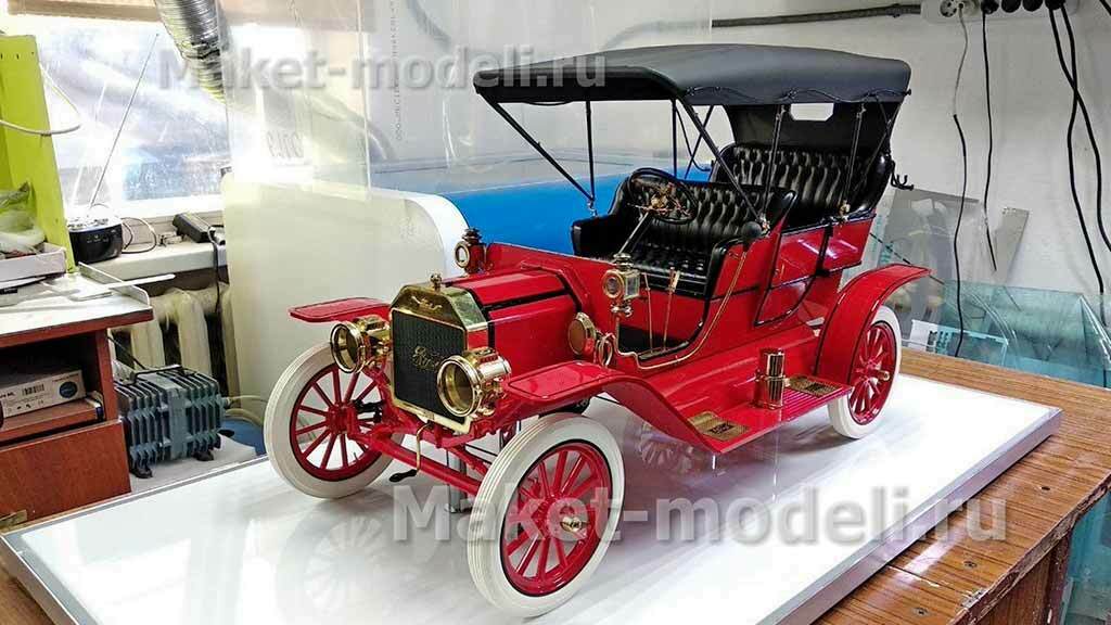 Тягач компоновки с высокой спальной кабиной (high-roof sleeper cab).   • Передняя светотехника: основные фары, блок дополнительных противотуманных/дальнобойных фар на переднем бампере.   • Солнечный козырёк над ветровым стеклом, сигнальные огни на крыше кабины.   • Фирменная решётка радиатора Volvo с логотипом и обозначением модели FH и мощности «480».   • Смоделированные элементы ходовой части: односкатные шины на управляемой передней оси и ведущей задней.   • Сцепка с трёхосным полуприцепом прямоугольного сечения (контейнер/фургон).    Модель установлена на ровной поверхности, на фоне стеллажей с ячейками для хранения и коробок с другими моделями.