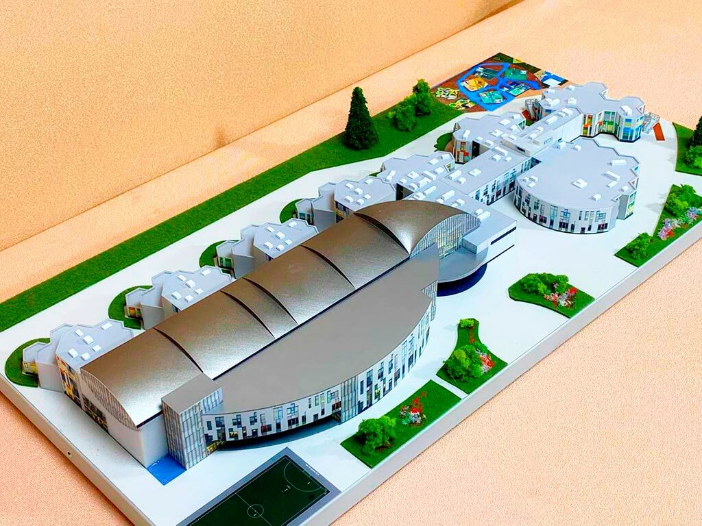 3-D масштабный архитектурный макет гимназии с модульными зданиями, купольным актовым залом, зонированной территорией и детской площадкой, изготовленный на заказ в макетной мастерской для демонстрации