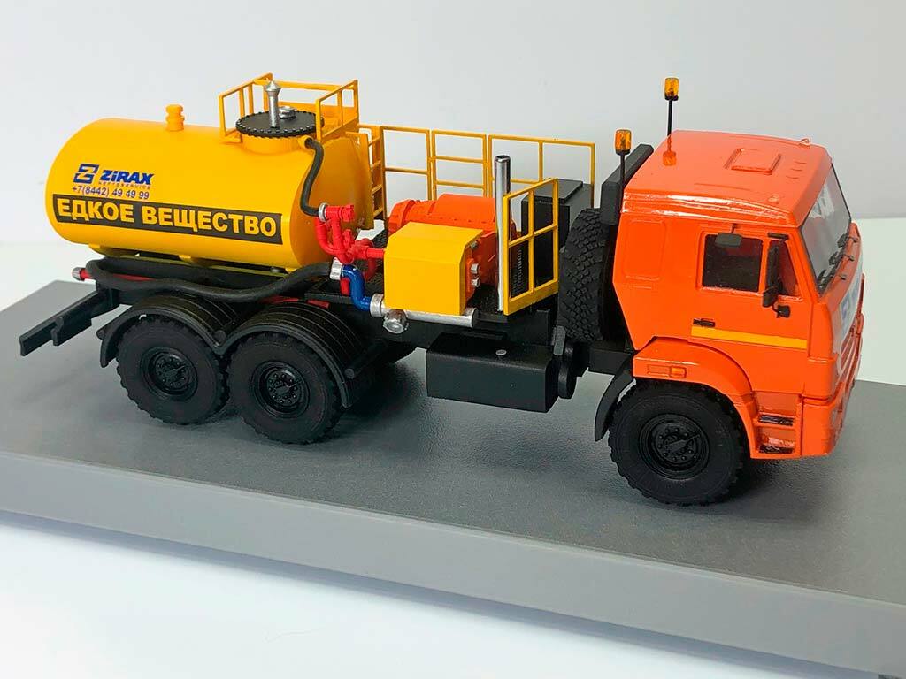3D-масштабная модель специализированного транспортного средства — агрегата для перевозки едких веществ на базе шасси КАМАЗ. Оранжевая кабина грузовика сочетается с ярко-жёлтой цистерной с надписью «Едкое вещество» и контактным телефоном компании «Zirax». Модель включает детализированную систему трубопроводов красного цвета, лестницу с перилами для доступа к верхней части цистерны, сигнальные огни на кабине и элементы крепления. Проработаны колёса с глубоким протектором, зеркала заднего вида, дверные ручки и другие мелкие детали. Реалистичная модель идеально подойдёт для демонстрации в тематических коллекциях, на выставках спецтехники и в рекламных материалах производителей промышленного транспорта.